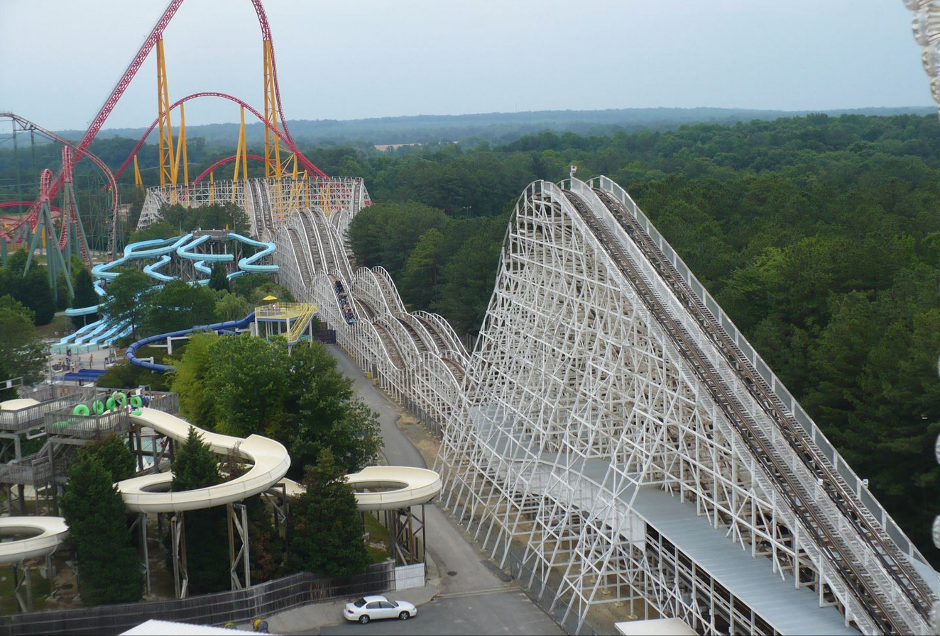 Aerial view of both tracks of Racer 75 during the day, the coaster is painted white.